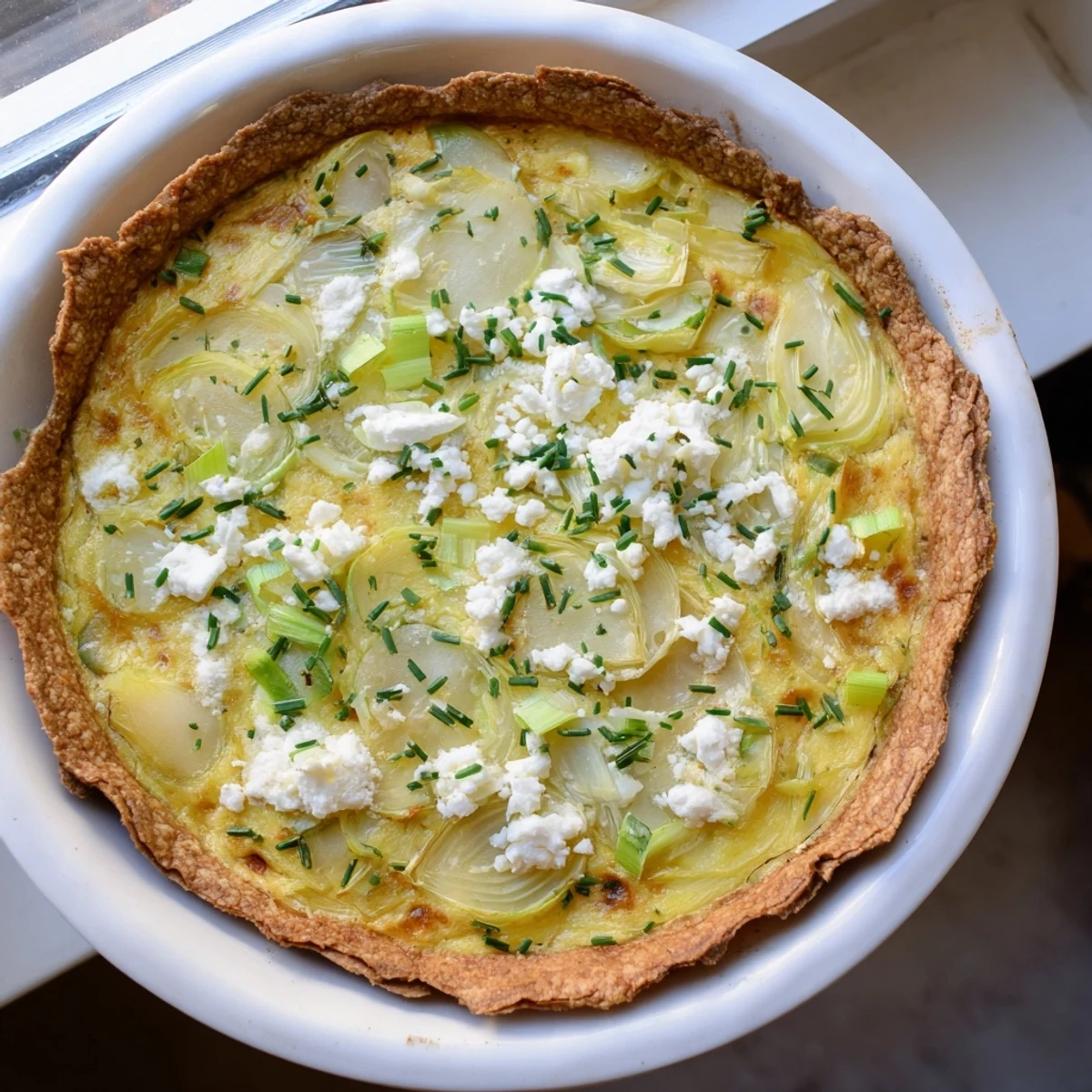 Golden-brown Potato Crust Leek and Goat Cheese Quiche, ready to serve for a delightful brunch.
