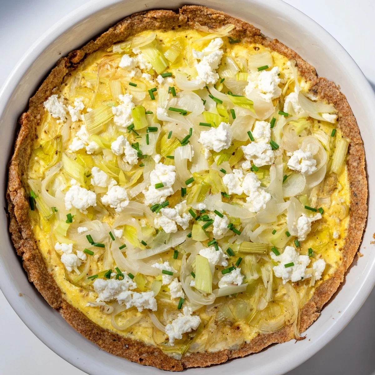 A beautiful cross-section reveals the Potato Crust Leek and Goat Cheese Quiche's creamy filling and flaky crust.