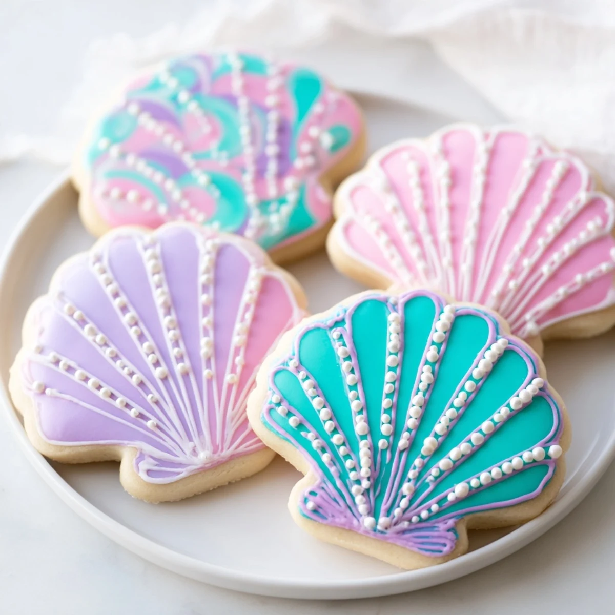 Delicate pastel Seashell Sweets, beautifully decorated sugar cookies waiting to be enjoyed at a party.