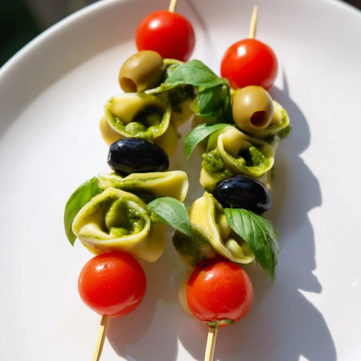 Appetizer Skewers: colorful tortellini, pesto, and olives arranged beautifully on a wooden skewer.