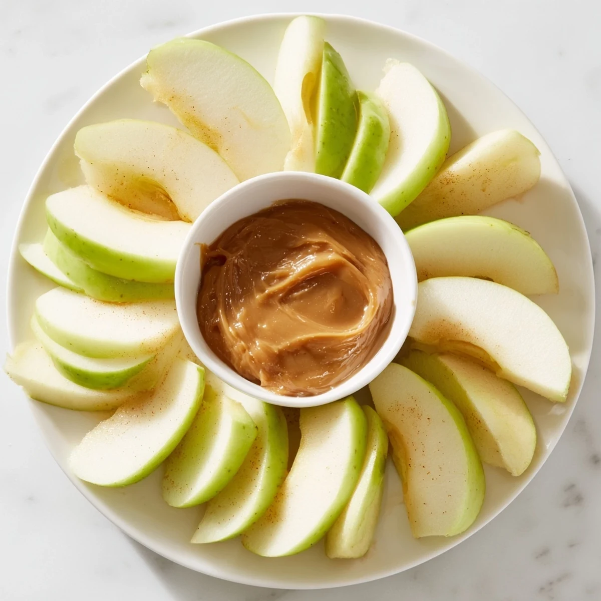Crisp apple slices surround a homemade, glossy caramel dip, perfect for dipping in this Apple Slices dish.