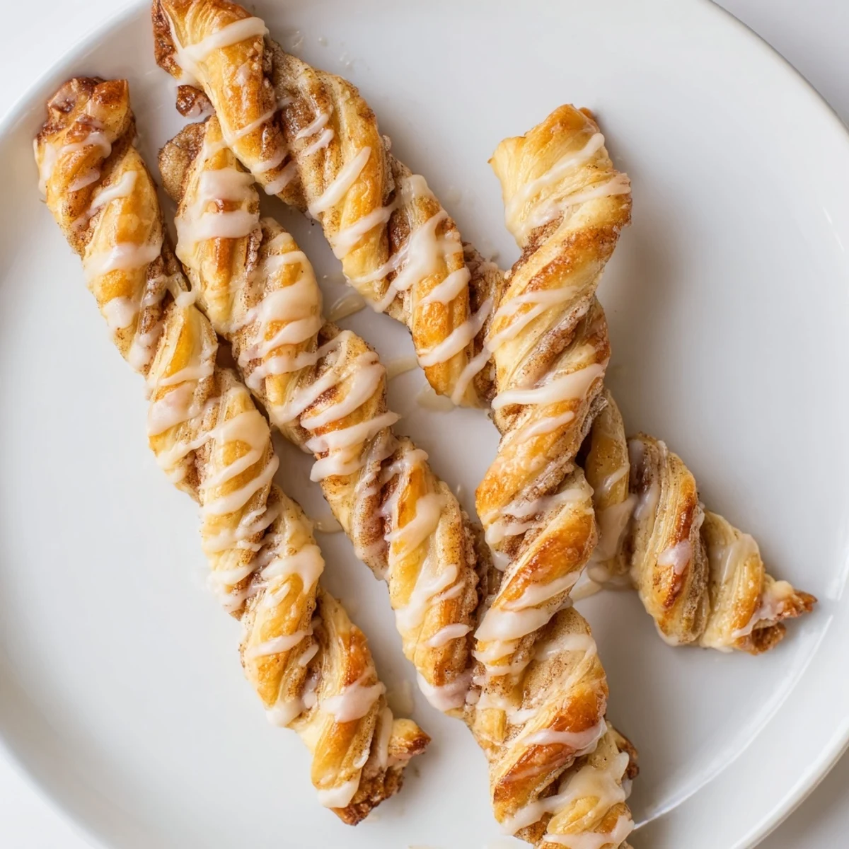 Enjoy freshly glazed Air-Fryer Cinnamon Roll Twists; warm and sweet, offering classic cinnamon roll flavor.