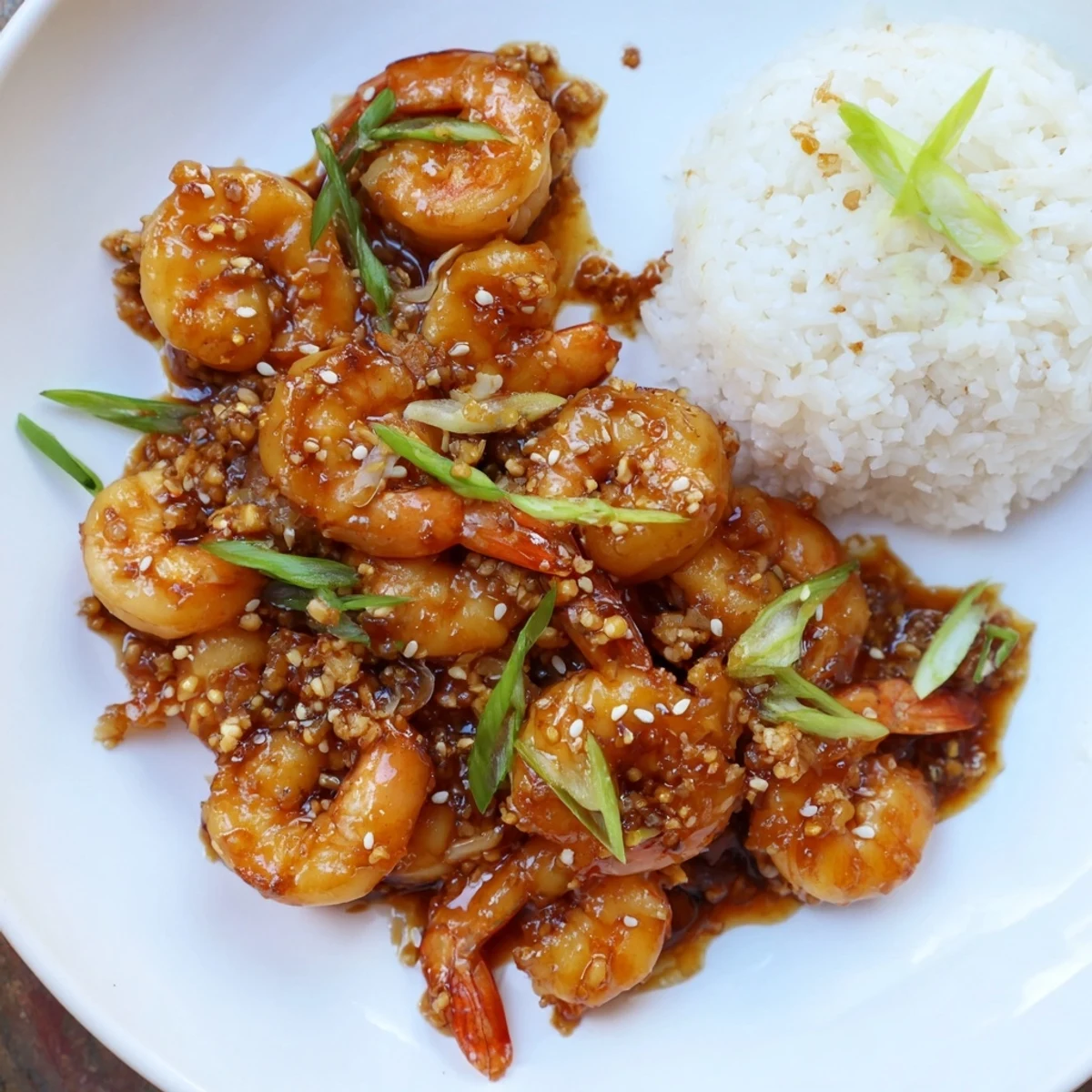 Honey Garlic Shrimp sizzling in a skillet, glistening with a sweet and savory sauce.