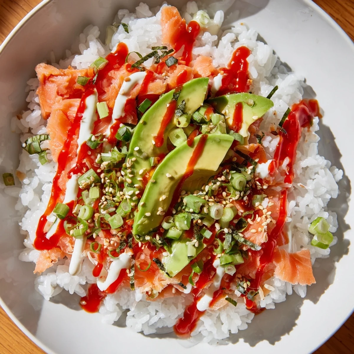Flaky salmon nestled with seasoned rice, a classic salmon rice bowl ready to enjoy with avocado.