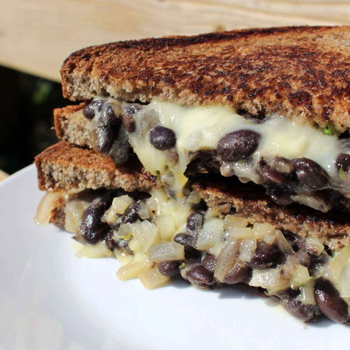 A close-up of a perfectly grilled Black Bean Grilled Cheese, showcasing the crispy bread and cheesy filling.