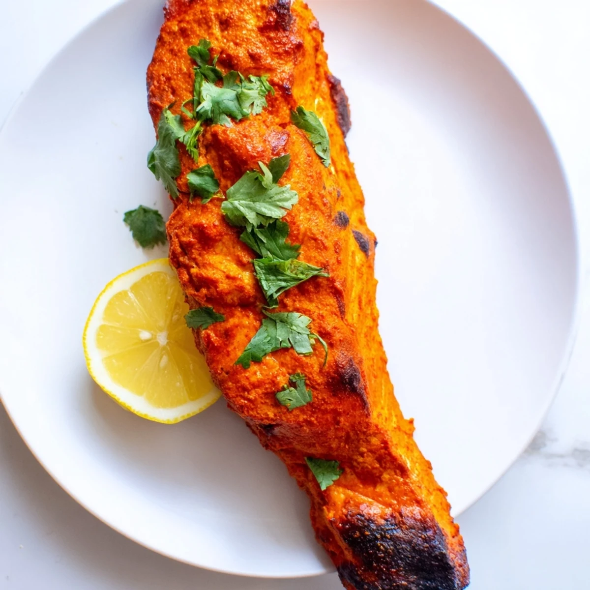 Flavorful Indian Tikka Salmon, served with lemon wedges, is a delicious, easy, and healthy meal.
