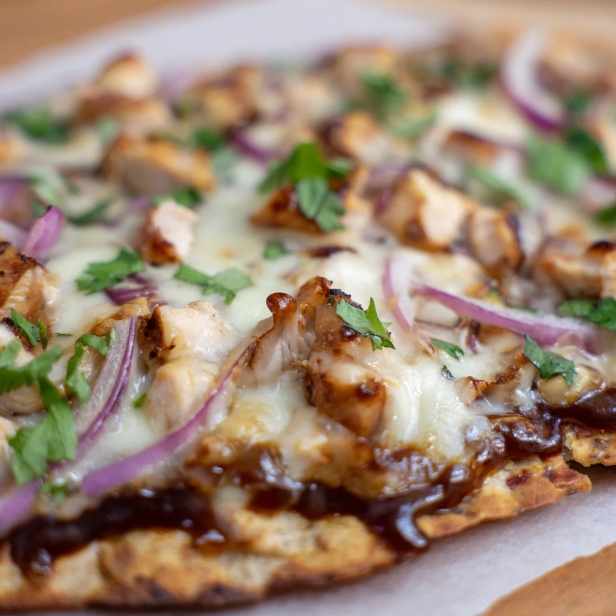 Slice of savory BBQ Chicken Flatbread topped with tender grilled chicken and sweet red onion