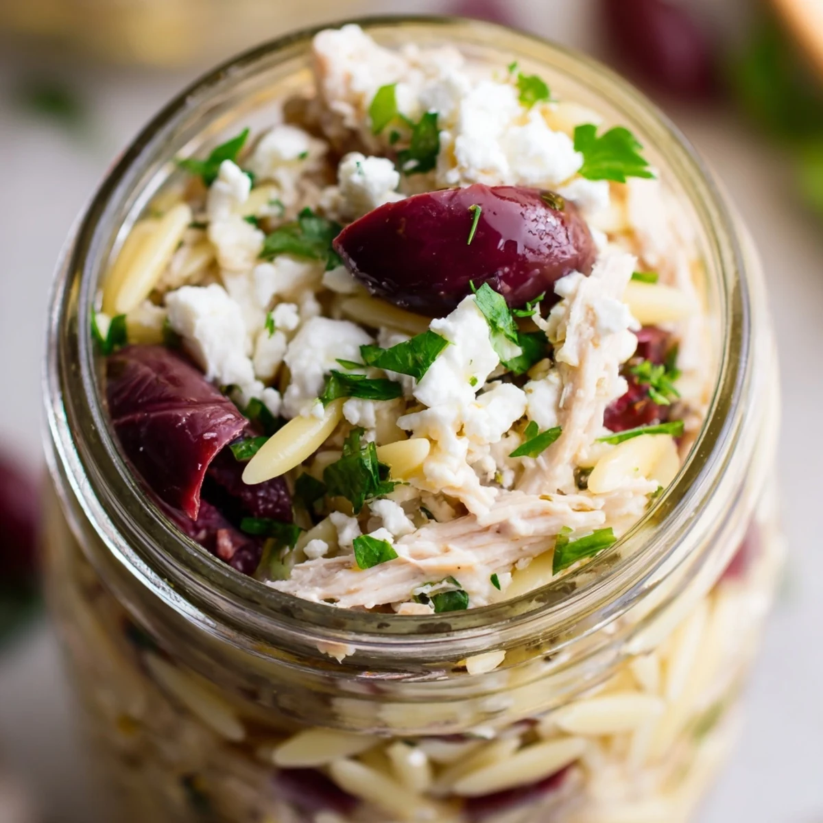 Stacked Greek Pasta Chicken Salad Jars with orzo, juicy chicken, briny olives, and creamy feta.  