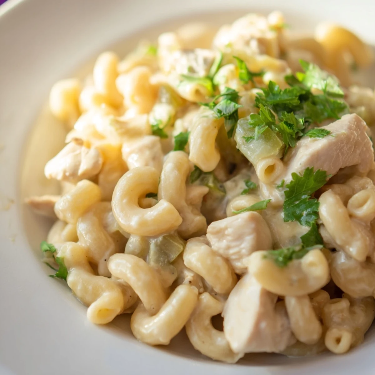 Comforting Green Chili Chicken Mac garnished with jalapeño slices, highlighting melty Monterey Jack and sharp cheddar in a creamy dish.