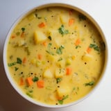Steaming Creamy Curry Comfort Potato Soup: the vibrant colors of carrots and potatoes blend beautifully.