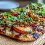 Juicy grilled peaches and creamy Brie melt together on crispy flatbread, finished with fresh basil and honey drizzle.  