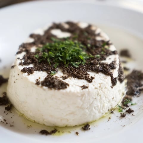 Elegant Victorian Cameo appetizer: creamy cheese circles adorned with striking black olive tapenade silhouettes.