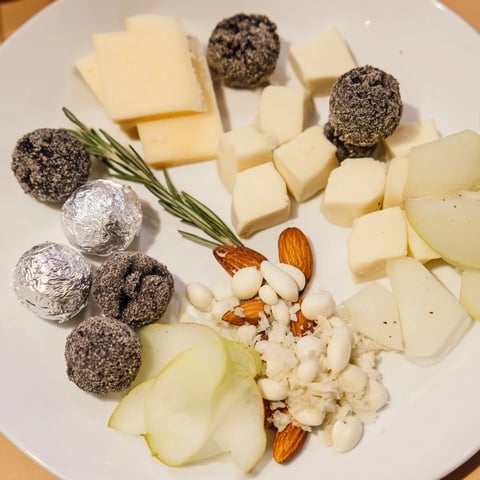 Elegant The Silver Screen cheese board boasting truffle brie and silver-wrapped chocolates, ready to serve.