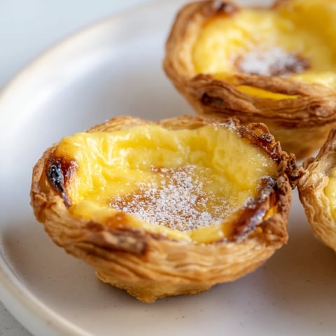 Golden-crusted Portuguese egg tarts, with a rich, creamy custard filling and a cinnamon dusting.