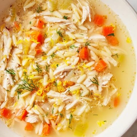 Steaming bowl of Chicken Lemon Orzo Soup with tender chicken, orzo pasta, and fresh dill garnish.
