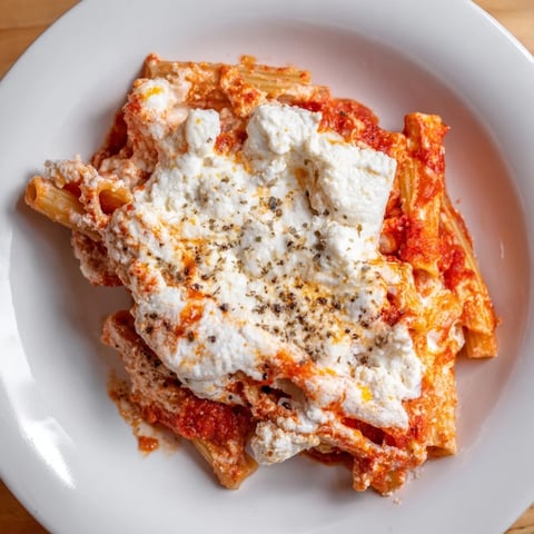 Golden, bubbly mozzarella tops layers of ziti pasta, rich tomato sauce, and creamy ricotta in a baked dish.