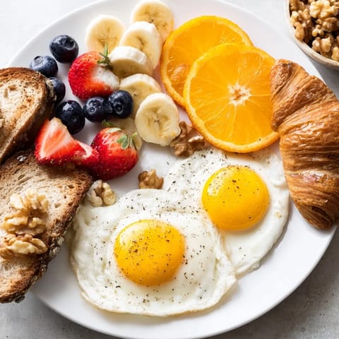 Golden croissants, berries, and yogurt adorn this delicious Soleil Matinal breakfast, drizzled with honey.