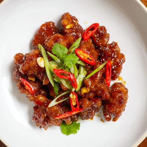 A close-up of steaming Vietnamese Caramel Chicken, showcasing the savory caramel glaze's sticky texture.