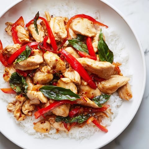 Aromatic Thai Basil Chicken Bowls: a close-up that shows glistening chicken and holy basil alongside rice.