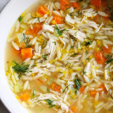 A comforting Mediterranean soup featuring bright lemon notes, diced vegetables, and shredded chicken in a savory broth.