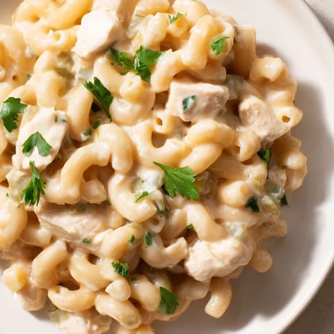 Green Chili Chicken Mac in a rustic skillet, featuring tender pasta coated in a cheesy sauce with diced green chiles.
