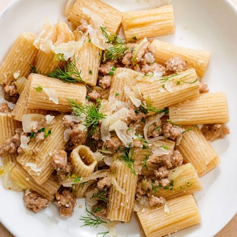 A close-up of Winter Pasta with Sausage and Fennel reveals a light, aromatic sauce clinging to the rigatoni, garnished with fresh parsley and a dusting of Parmesan.