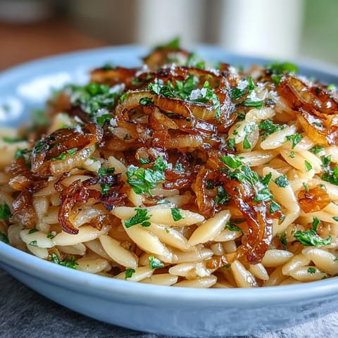 Golden caramelized onion orzo with melted parmesan, a comforting vegetarian delight.