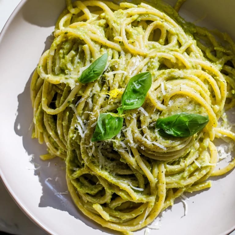 Freshly prepared creamy avocado pasta with a touch of chili flakes, ready for a delicious, satisfying bite.