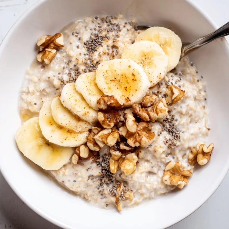 A creamy, comforting bowl of Microwave Banana Oats with visible banana and a sprinkle of cinnamon.