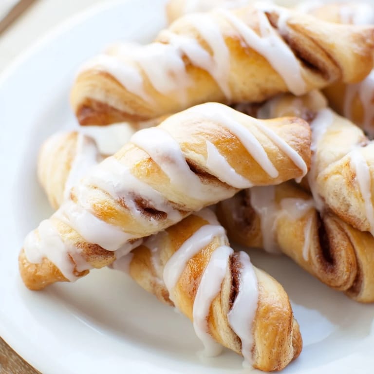 These air-fried Cinnamon Roll Twists look like golden, twisted dough, drizzled with a sweet vanilla glaze.