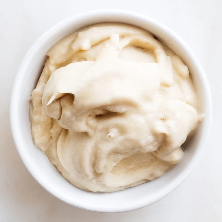 A bowl of fresh 2-Ingredient Banana Ice Cream: naturally sweet, frozen bananas blended with milk for a simple, tasty dessert.