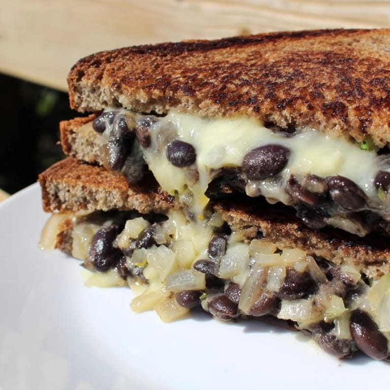 A close-up of a perfectly grilled Black Bean Grilled Cheese, showcasing the crispy bread and cheesy filling.