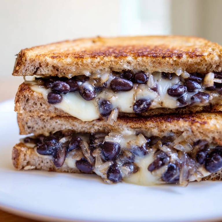 Enjoy a delicious vegetarian meal: the warm, comforting Black Bean Grilled Cheese, served sliced and ready.