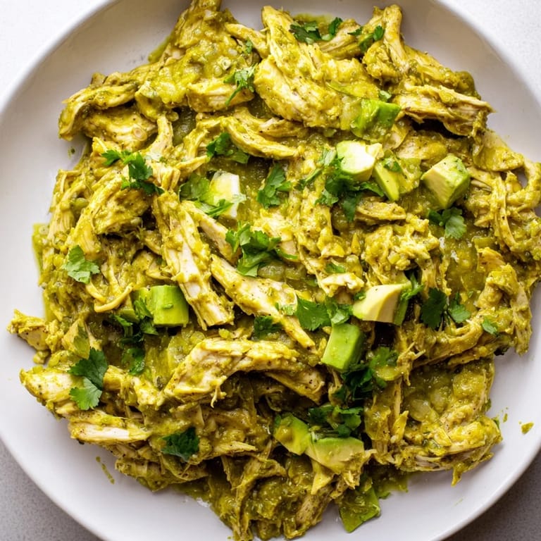 Sizzling boneless chicken thighs seared in a Dutch oven before being braised in a vibrant, charred green salsa verde, creating a rich and comforting Mexican classic main dish.